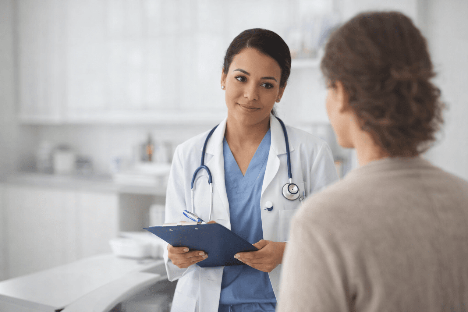 Doctor with clipboard consulting with patient about symptoms